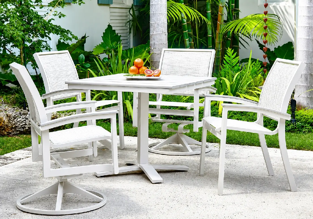 Elegant white outdoor dining set with woven sling chairs creating a refined resort-inspired patio and poolside dining space.